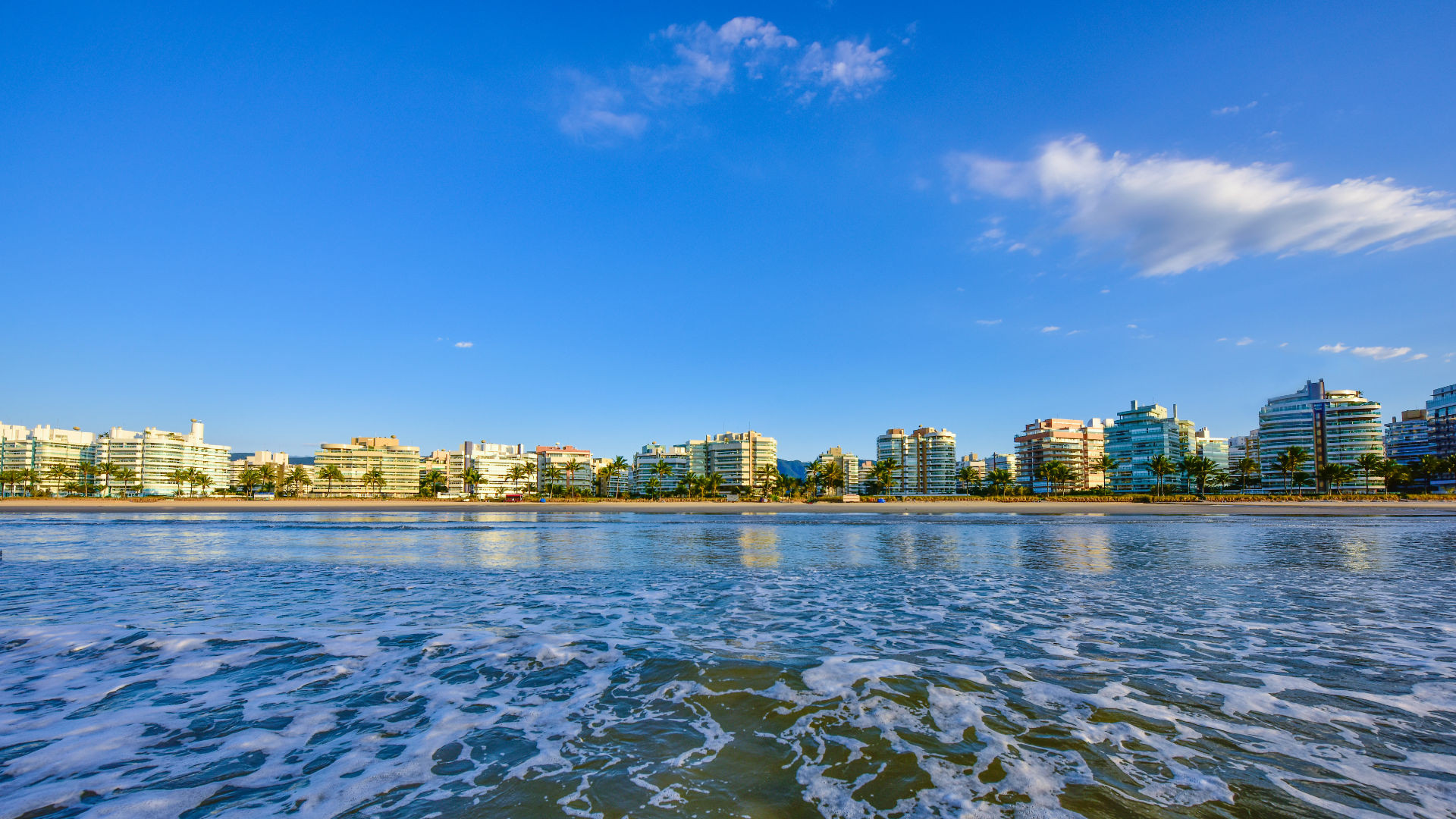 Foto de prédios na praia com céu azul.